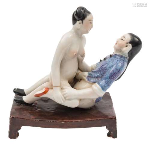 A Chinese porcelain erotic figural group: depicting an amorous man and woman,