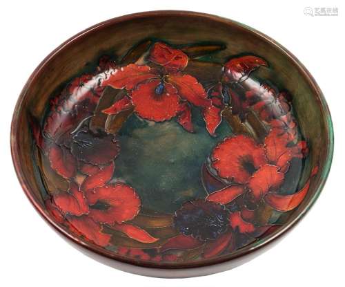 A Moorcroft pottery bowl: of shallow circular form tube lined in the Iris pattern under flambé