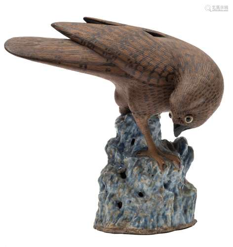 A Chinese stoneware model of a hawk: with brown biscuit plumage and dark markings,