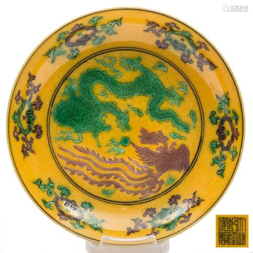A small Chinese yellow ground phoenix and dragon dish: incised and painted in green and aubergine