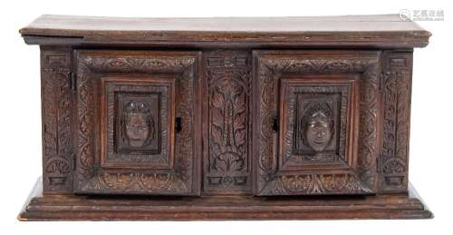 An early 18th Century Continental carved oak table cabinet:, with a moulded cornice,