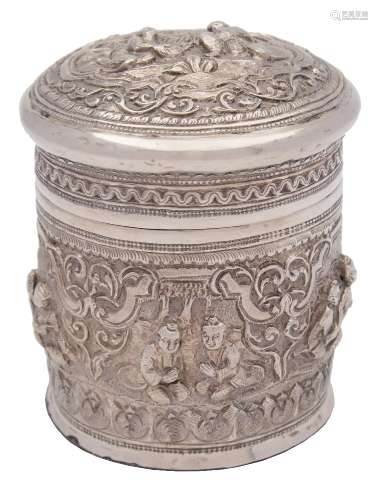 A Burmese silver jar and cover: the domed pull-off lid with embossed decoration of figures seated