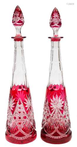 A pair of ruby overlaid clear glass decanters and stoppers: of slender tapering form with star and