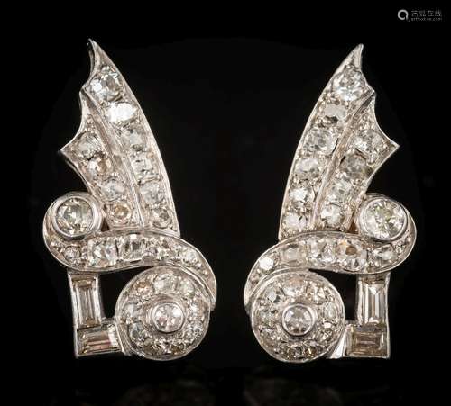 A pair of early 20th century diamond earrings: of scroll ribbon design with graduated old,