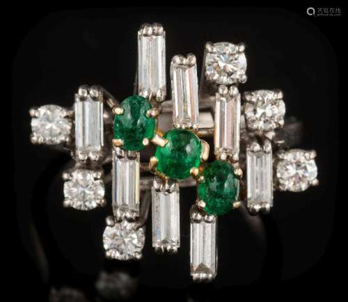 An emerald and diamond informal cluster ring: with three oval cabochon emeralds,