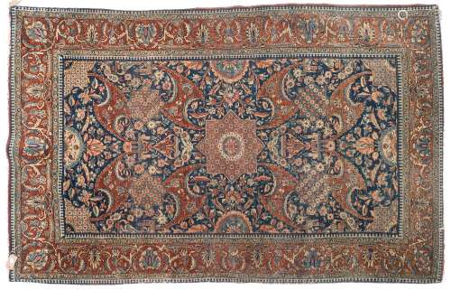 A Kashan rug:, the indigo field with a central geometric stellar medallion and all over palmette,