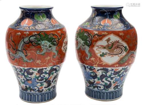 A pair of Japanese Imari baluster vases: painted predominantly in underglaze blue,
