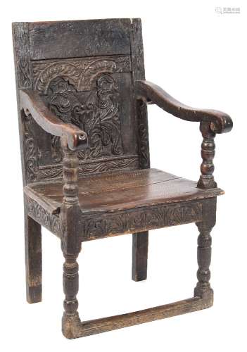 A 17th Century carved oak open armchair:, the panelled back with arcaded,
