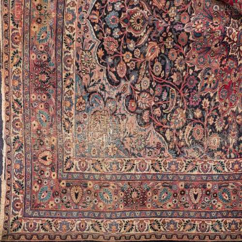 A Tabriz carpet:, the indigo cartouche field with a central rose geometric flowerhead medallion,