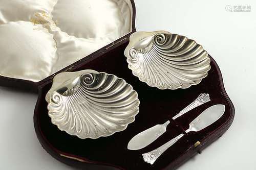 A late victorian cased pair of butter shellsand two matching butter knives, by