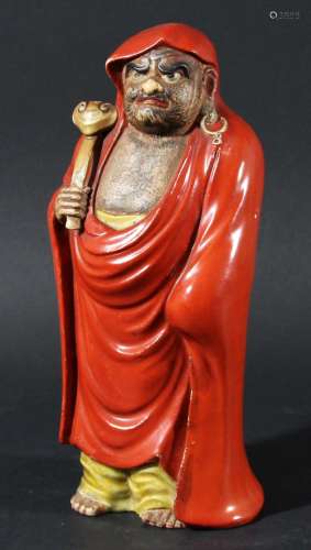 Chinese figure of a monk,late 19th or 20th century, standing wearing a red