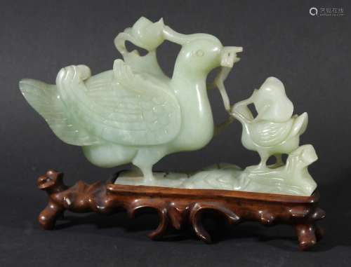 Chinese celadon jade group,carved as a duck and ducking, on a hardwood stand,