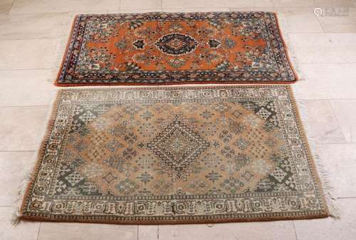 Two hand-knotted carpets. Both light in color with