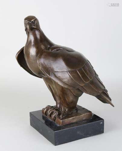 Large bronze eagle on black marble base. 21st century.