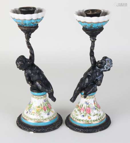 Two decorative brass candlesticks with putti and