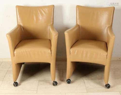 Six modern leather, beige colored armchairs on wheels.