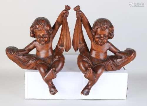 Two times 18th - 19th century walnut carved putti.