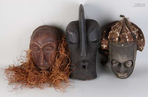 Three old African wood-stained masks. Consisting of: