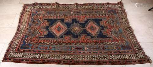 Old hand-knotted Persian carpet with old restorations