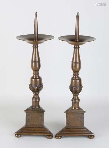 Two large antique bronze candlesticks with engravings.