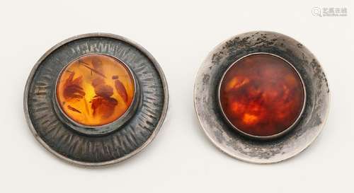 Two silver brooches with amber, one round brooch with