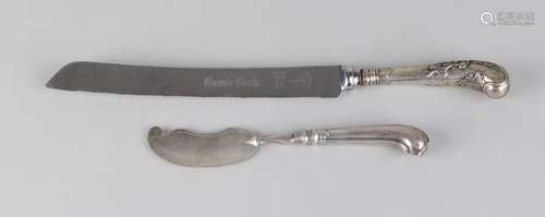 Two knives with a silver handle, a bread knife with a