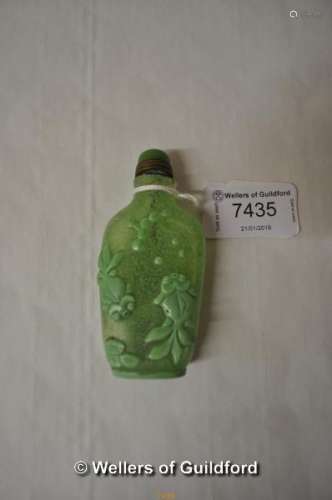 A Chinese green glass scent bottle decorated with koi in a pond.