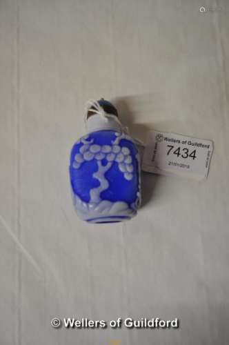 A Chinese pate sur pate scent bottle carved with a man under a tree.