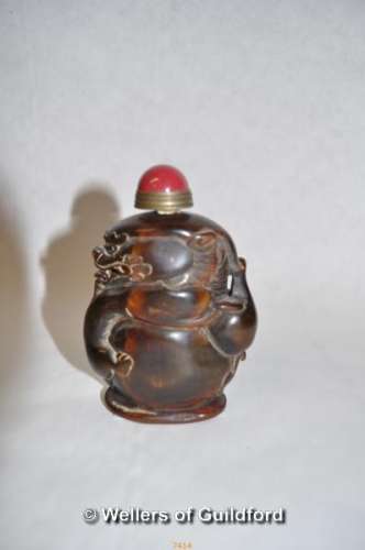 A Chinese horn snuff bottle carved as a drogon, red cabochon stone to lid, 8.5cm tall.