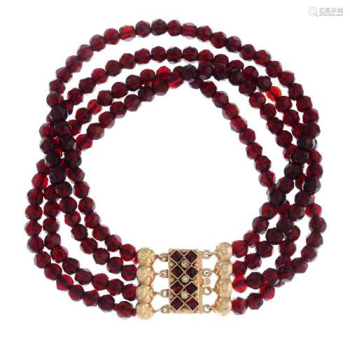 A garnet and split pearl four-row bracelet. The faceted