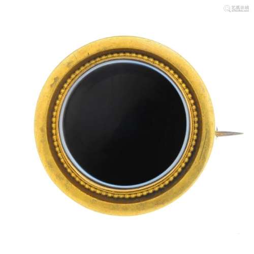 A late Victorian gold onyx brooch. The circular onyx