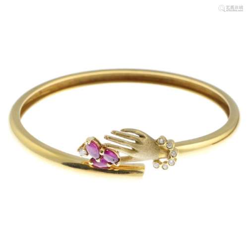 A ruby and diamond hand bracelet. The front designed as
