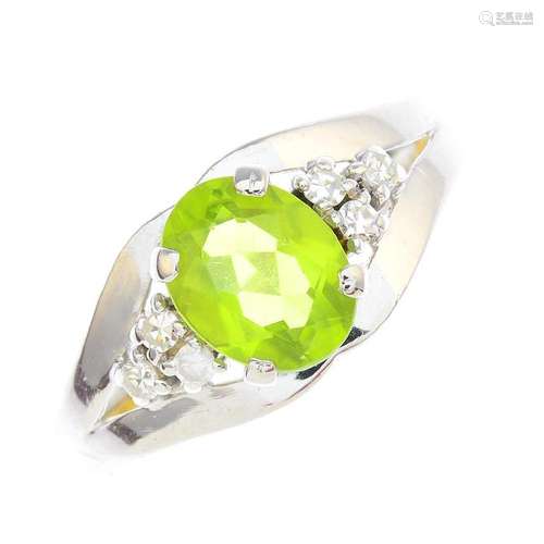 A peridot and diamond dress ring. The oval-shape