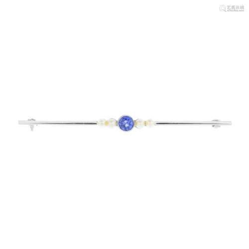 A tanzanite and split pearl bar brooch. Designed as a