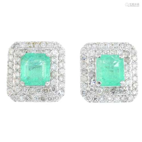 A pair of emerald and diamond earrings. Each designed