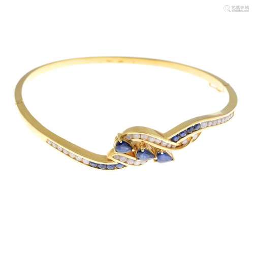 A sapphire and diamond hinged bangle. The front