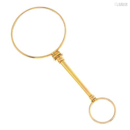 A Victorian gold magnifying glass. The circular glass,