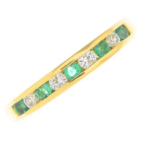 An 18ct gold emerald and diamond half eternity ring.