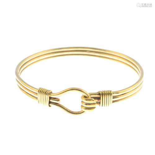 A 9ct gold bangle. Designed as a grooved bangle, with