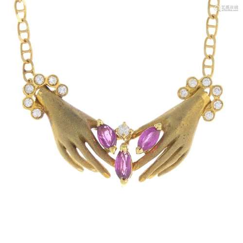 A ruby and diamond hand necklace. The front designed as