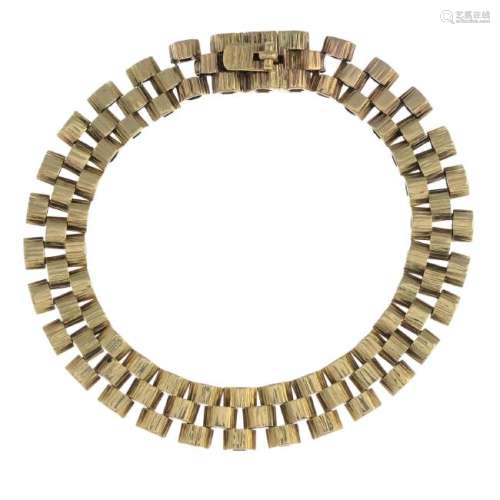 A 9ct gold bracelet. Designed as a three rows of