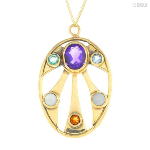 A 9ct gold gem-set pendant. The openwork oval, with