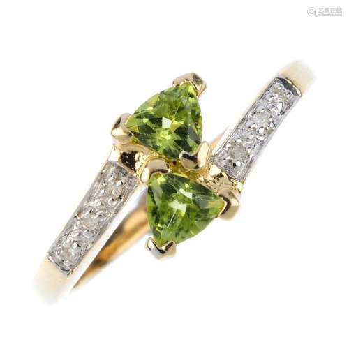 A 9ct gold peridot and diamond crossover ring. The