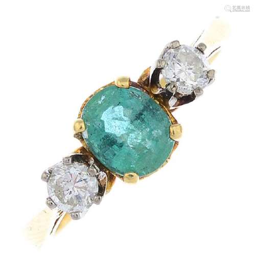 An 18ct gold emerald and diamond three-stone ring. The