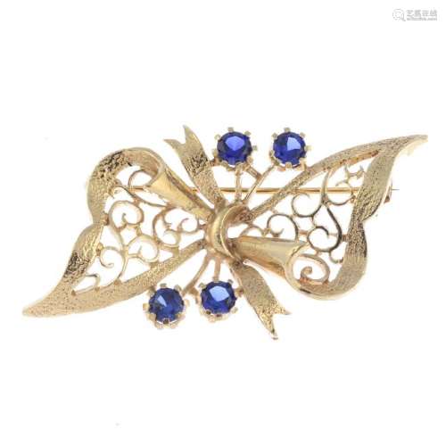 A 9ct gold synthetic sapphire brooch. The openwork bow,