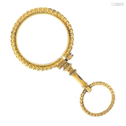 A Victorian gold magnifying glass. The circular lens,