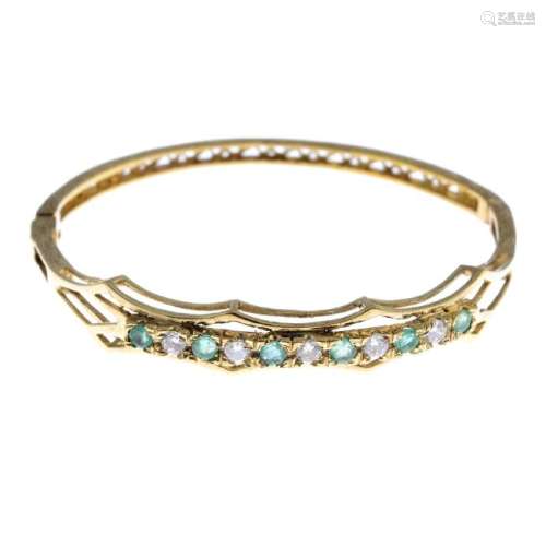 An emerald and cubic zirconia hinged bangle. The