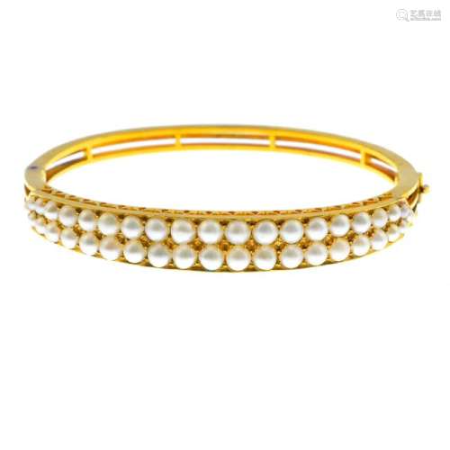 An early 20th century gold split pearl bangle. Designed