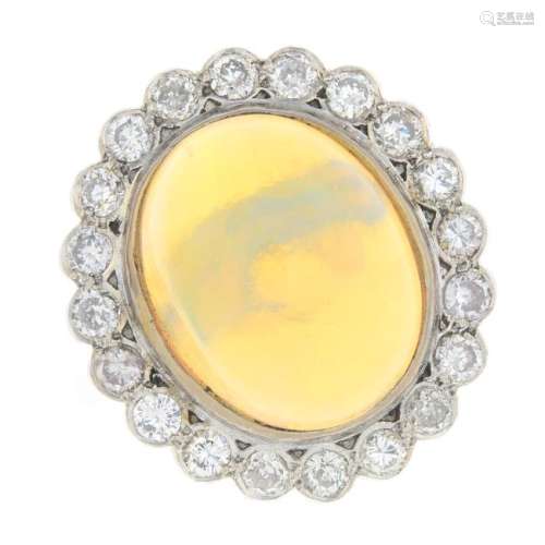 A platinum opal and diamond cluster ring. The oval opal