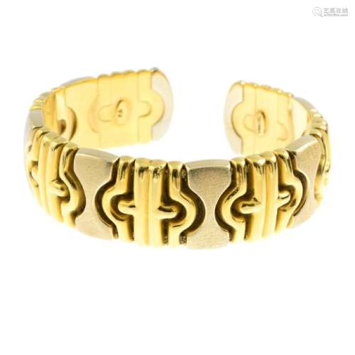 An 18ct gold bangle. The flexible cuff, comprising a